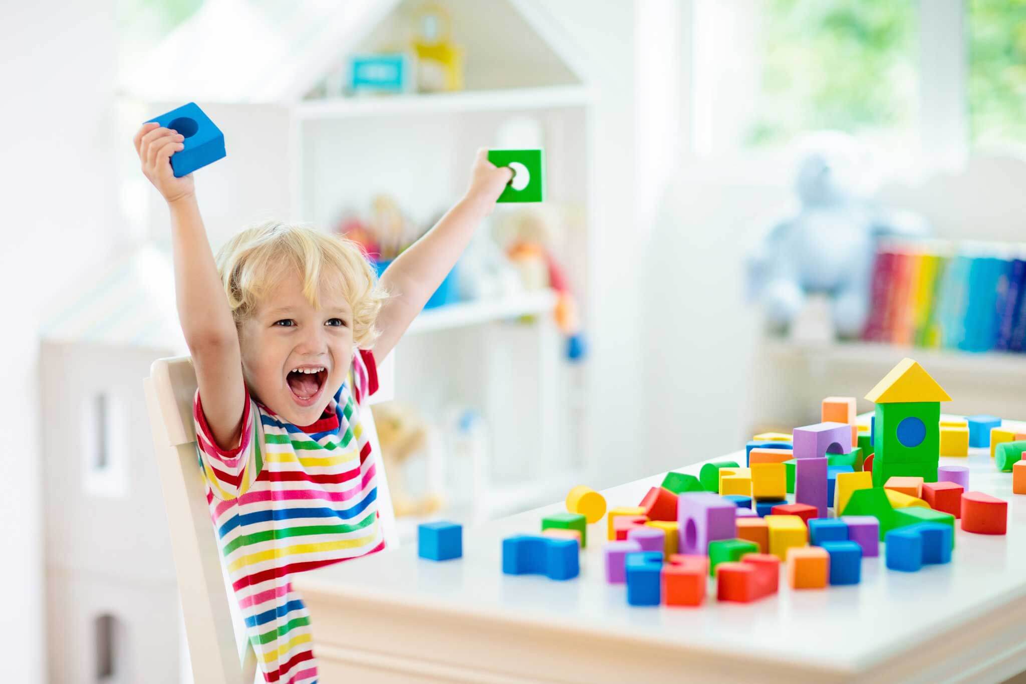 child excited while playing with blocks