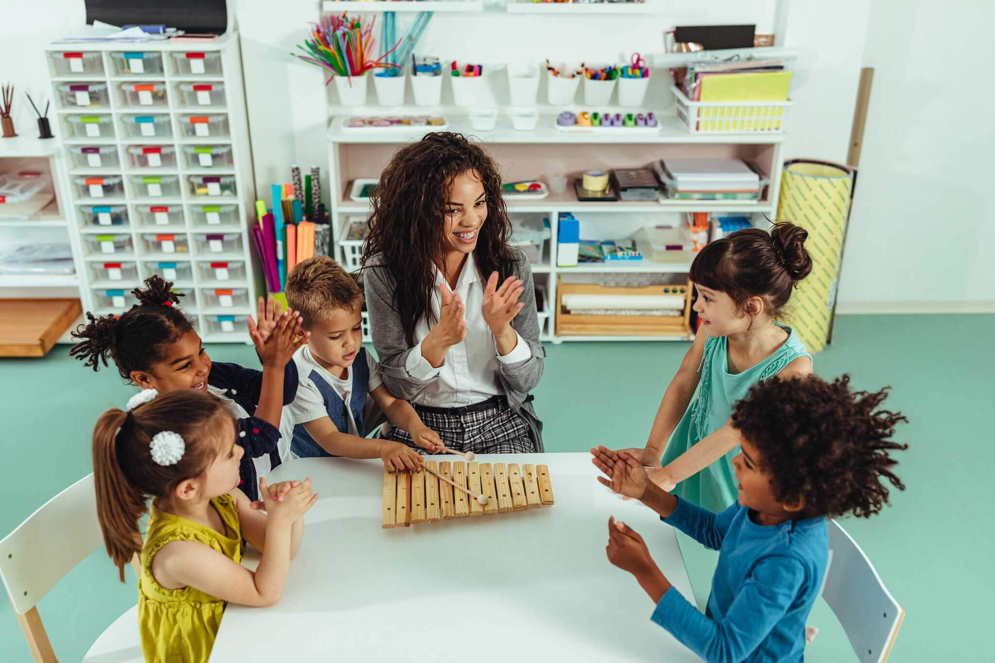 daycare teacher playing xylophone with students