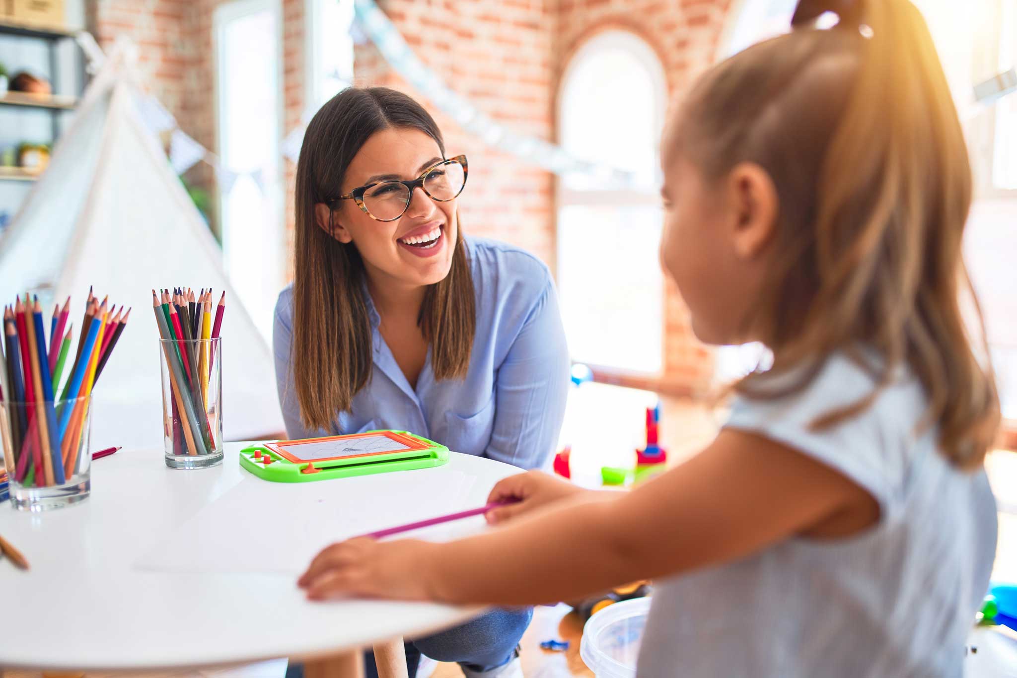 female daycare teacher working with young girl